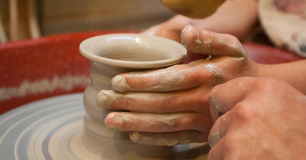 Child's hands at a potter's wheel